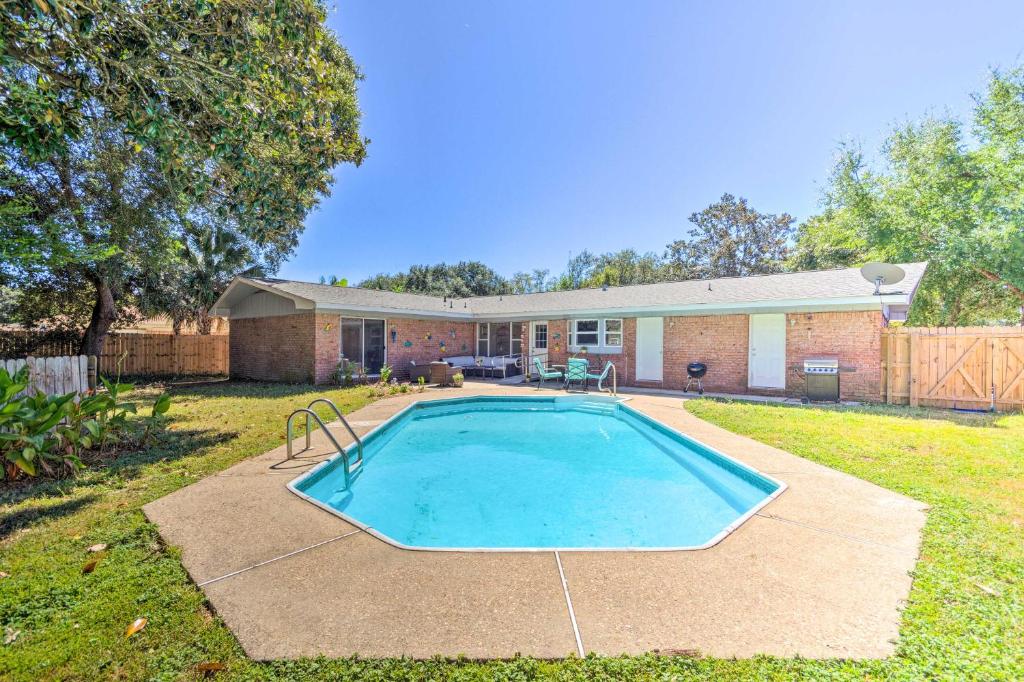 a swimming pool in the backyard of a house at Family Home with Private Pool and Fenced Yard! in Fort Walton Beach