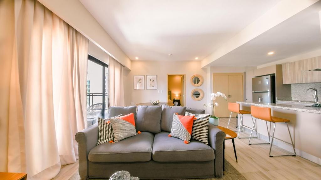 a living room with a couch and a kitchen at Fully Serviced Apartment at Regatta Living - 9F in Santo Domingo