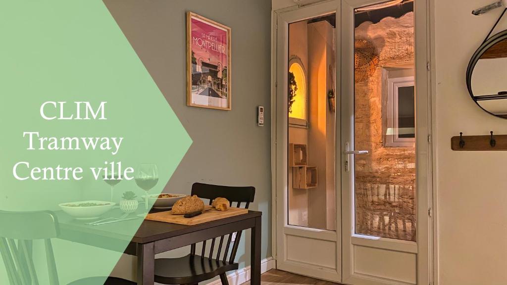 une salle à manger avec une table et une porte en verre dans l'établissement # CLIM - TRAM - Centre ville - Sous les toits #, à Montpellier