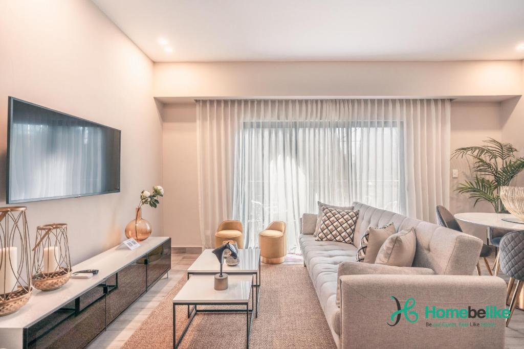 sala de estar con sofá y TV en Breakfast Included Fully Serviced Apartment at Regatta Living II - 204, en Santo Domingo