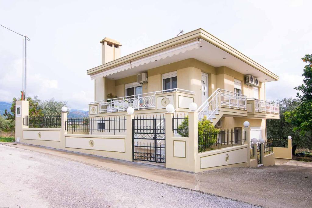 Villa Evdokia في يميناريا: منزل اصفر كبير امامه سياج