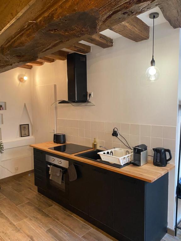 a kitchen with a sink and a counter top at Studio Manhattan WIFI Plein de charme in Gien