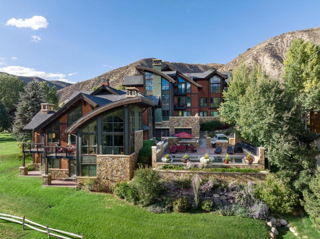 a large house with a mountain in the background at Impeccable Lakeside Penthouse in Avon