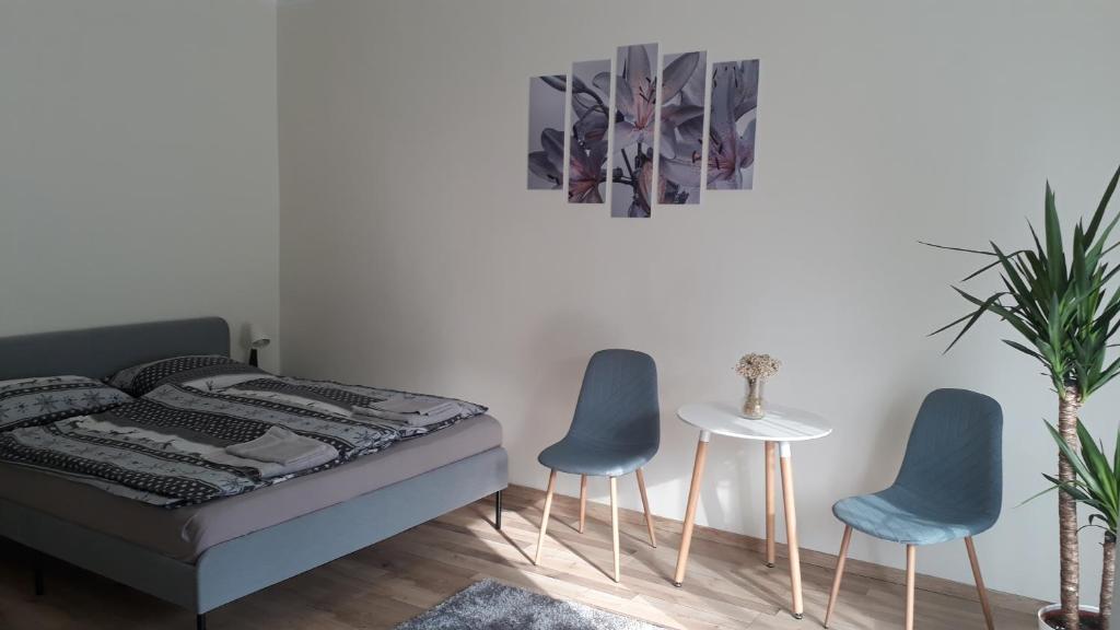 a bedroom with two blue chairs and a bed at Világos, kellemes lakás, jó közlekedéssel in Budapest