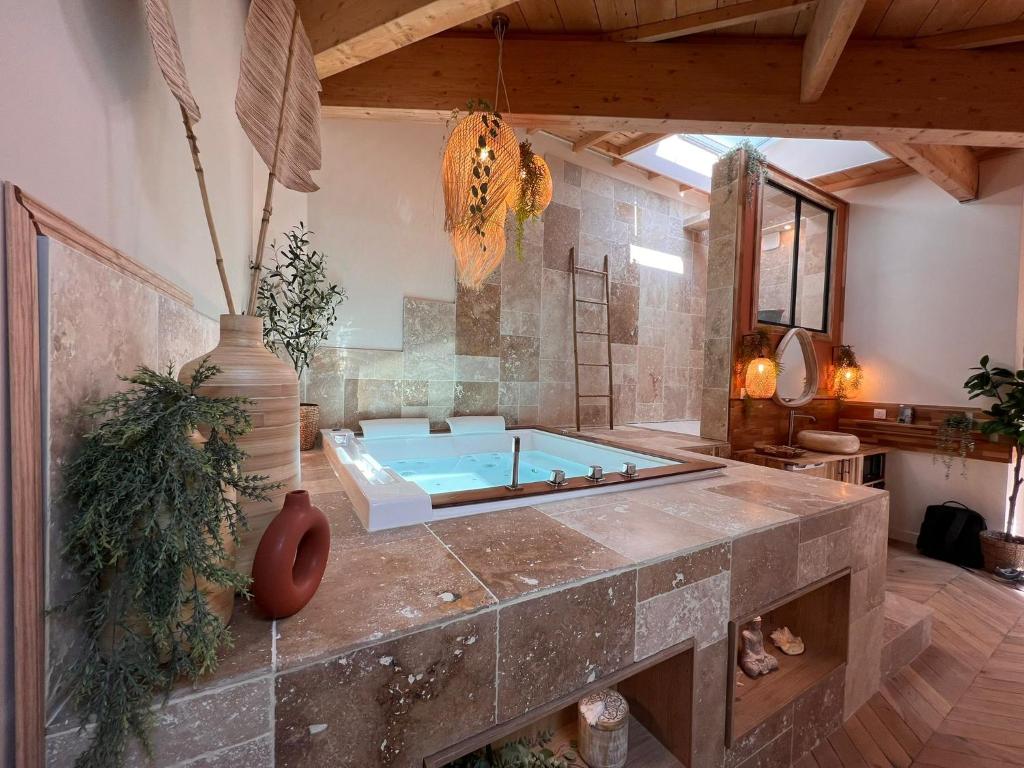 - une grande salle de bains pourvue d'une baignoire dans l'établissement Suite Bali Les Petits Plaisirs, à Angers