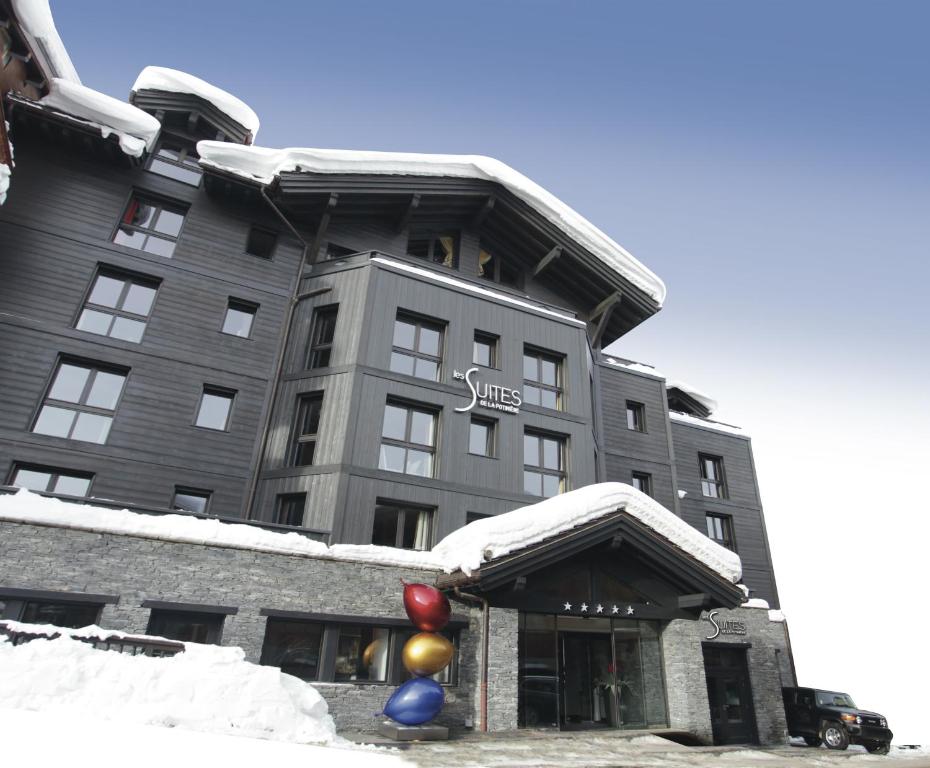 een gebouw bedekt met sneeuw met ballonnen ervoor bij Les Suites de la Potinière in Courchevel