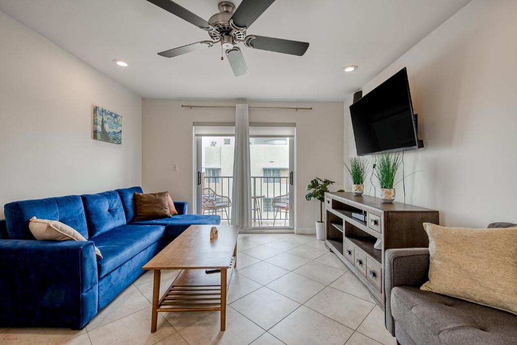 Hotel Samira's South Beach Paradise, a living room with a blue couch and a tv at Samira's South Beach Paradise in Miami Beach