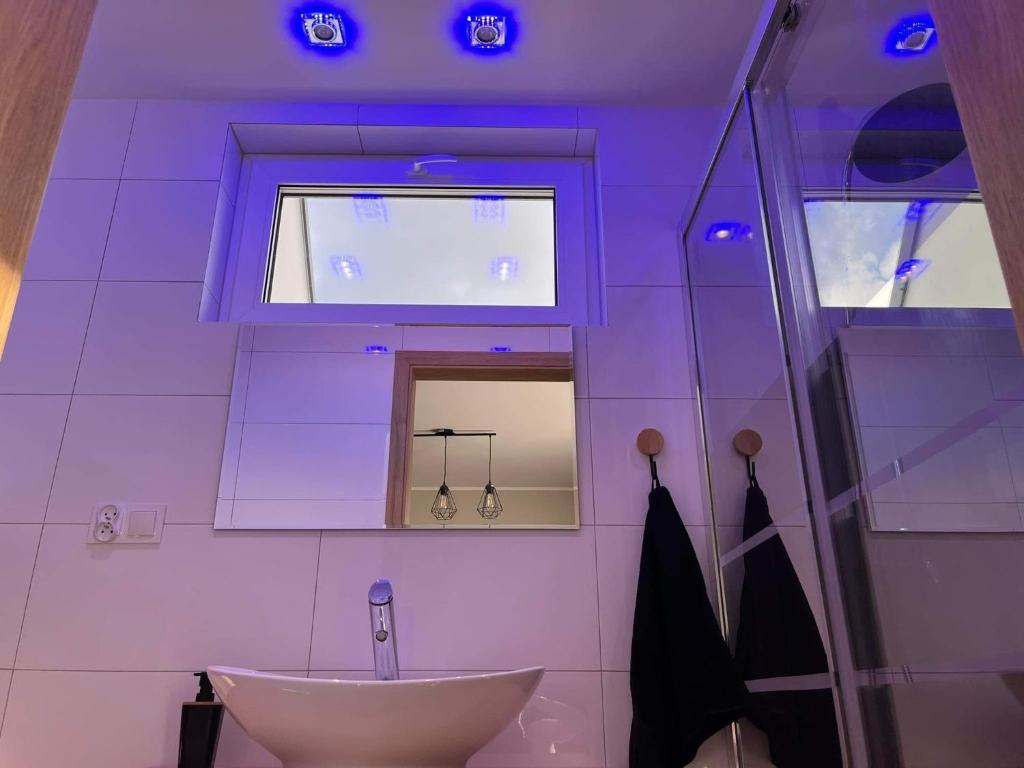 Fioletowa łazienka z umywalką i oknem w obiekcie Domek wypoczynkowy MK w mieście Puck