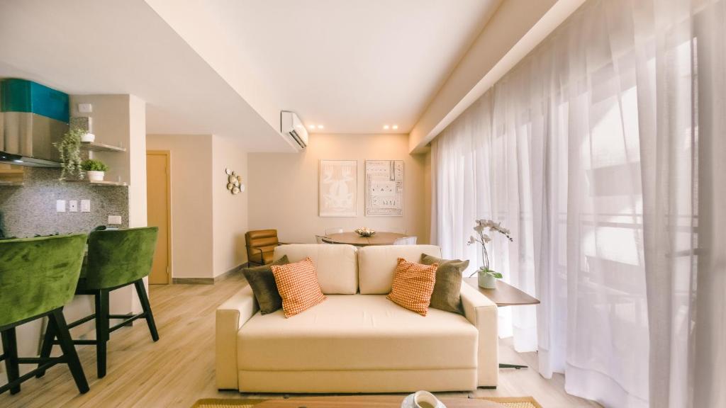 un soggiorno con divano bianco e tavolo di Fully Serviced Apartment at Regatta Living II - 703 a Santo Domingo