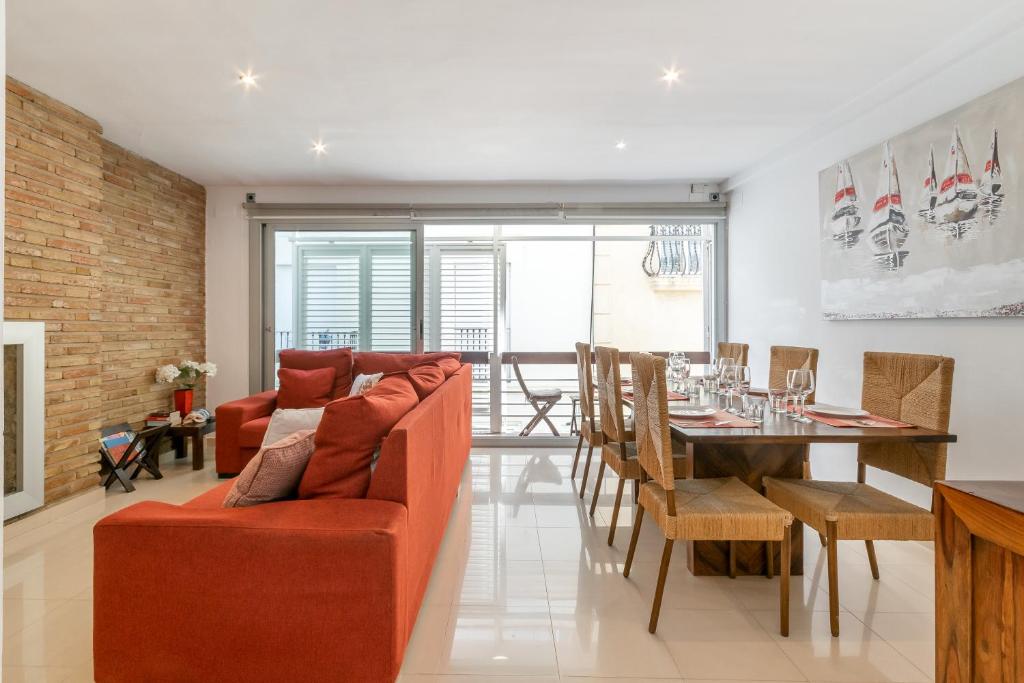 sala de estar con sofá rojo y mesa en Fragata Sitges Rentals, en Sitges
