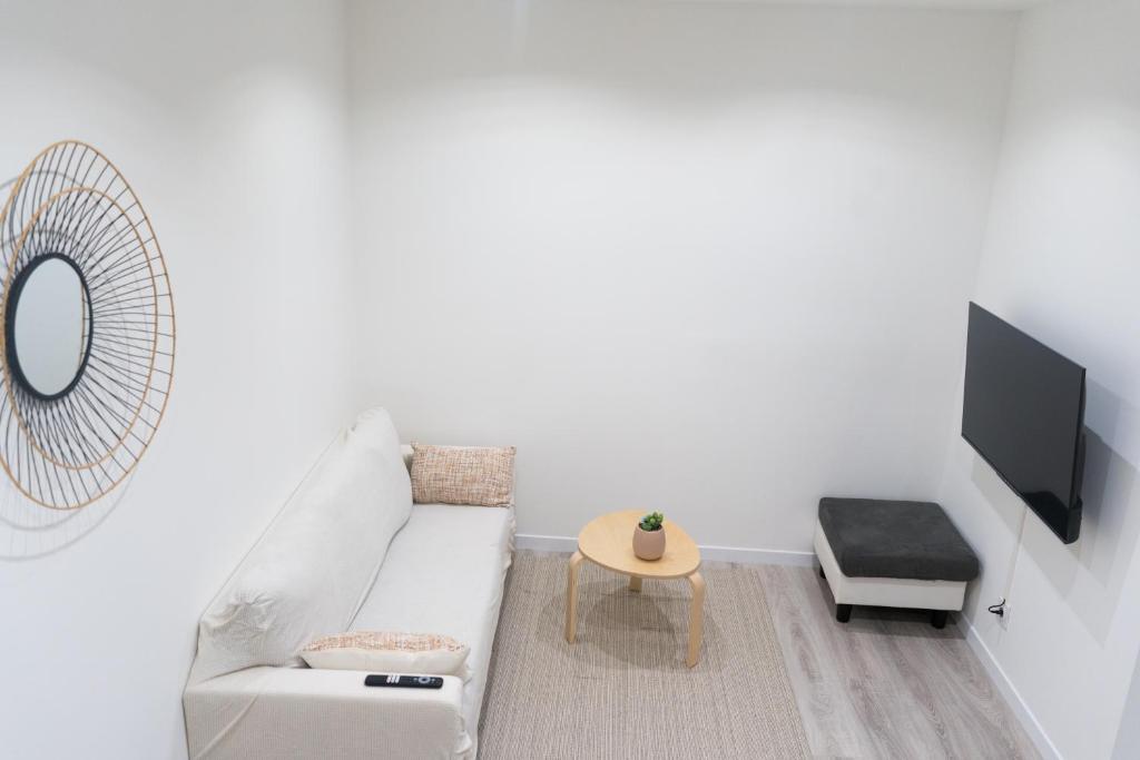 uma sala de estar branca com um sofá branco e uma mesa em Charmant appartement 2 pièces em Valence