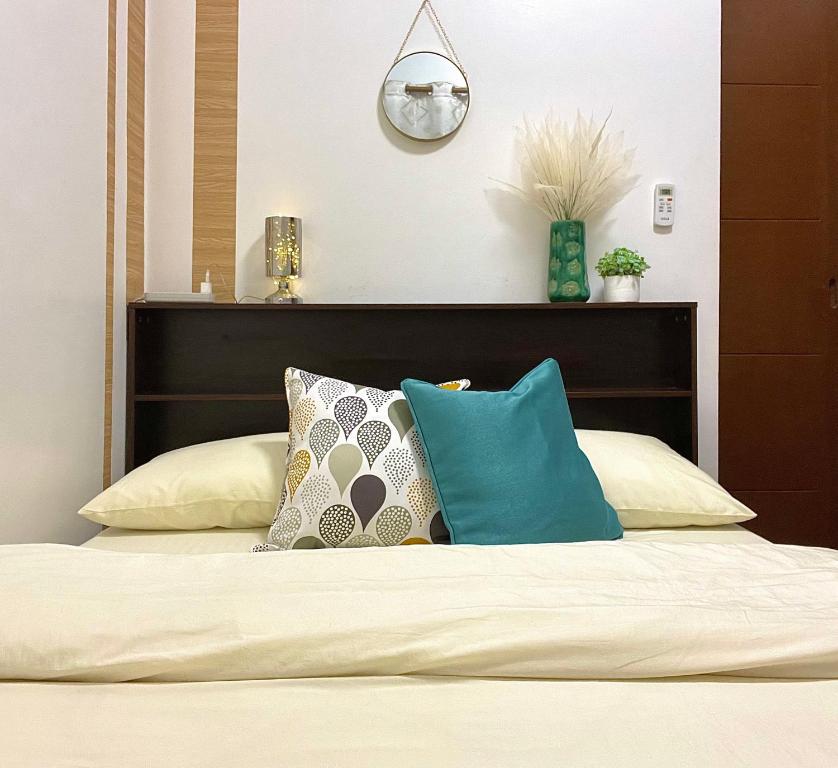- une chambre avec un lit et des oreillers dans l'établissement Althea's Cozy Apartment, à Manille