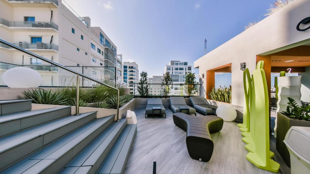 a balcony with couches and chairs on a building at Most exclusive Condo- Hotel in Town -802 in Santo Domingo