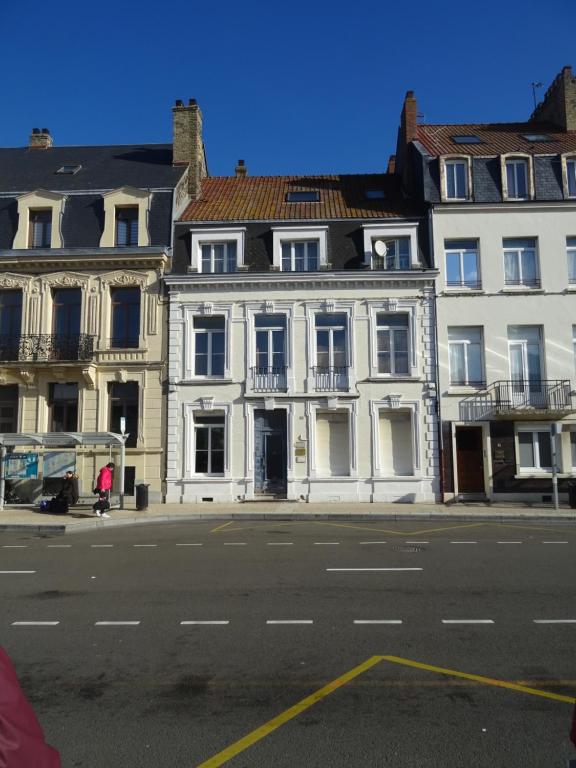 un grand bâtiment blanc sur le côté d'une rue dans l'établissement Charmant studio en centre-ville, à Boulogne-sur-Mer