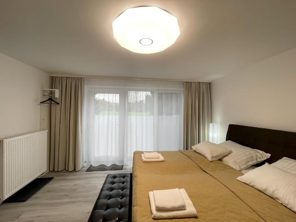 ein Schlafzimmer mit einem großen Bett und einem großen Fenster in der Unterkunft Smart Apartment l in Huncovce