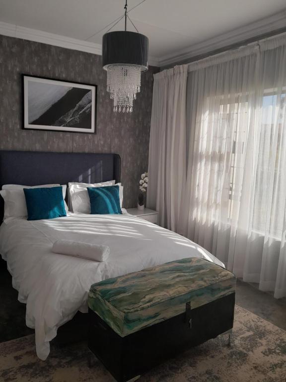 a bedroom with a large bed and a chandelier at Maso palace in Polokwane