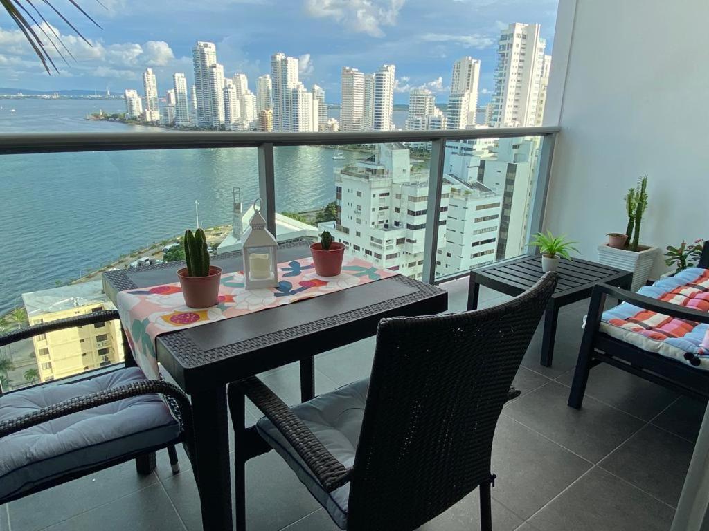 a table and chairs on a balcony with a view of the city at Lujoso Apartamento en Bocagrande in Cartagena de Indias