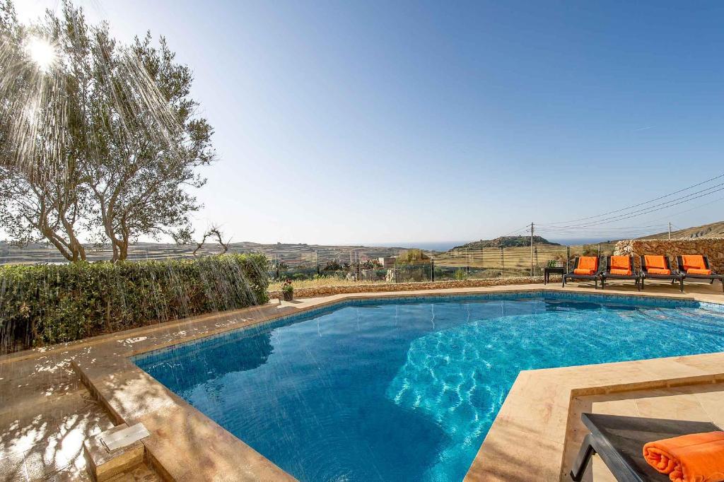 una piscina de agua azul en un patio en Dream by Hamlet Holiday Home, en Għasri