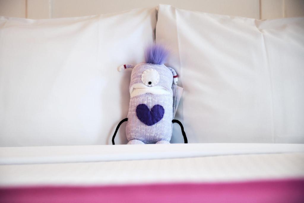 a stuffed animal is sitting on a bed at Summit Lodge Boutique Hotel by Paradox in Whistler