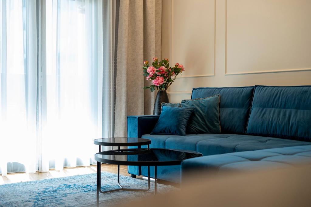 a living room with a blue couch and a table at GRAND LUX APARTMENTS in Banja Luka