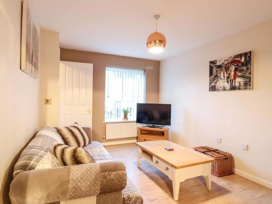 a living room with a couch and a coffee table at Wisteria Place in Tiptree