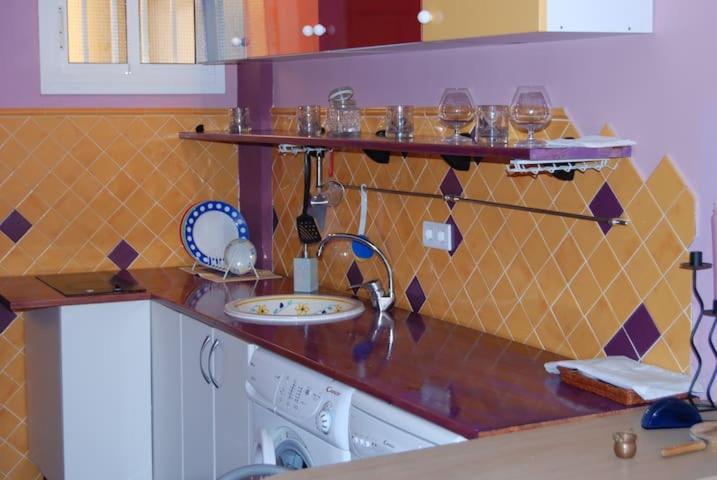 a kitchen counter with a sink and glasses on shelves at Sol y playa in Benalmádena