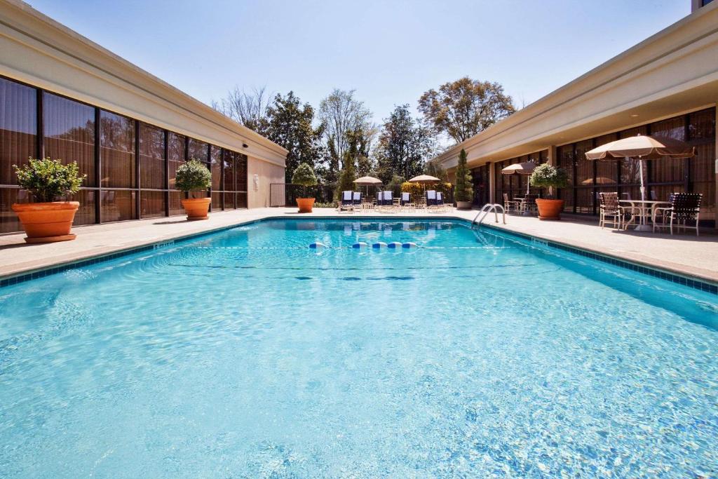 a swimming pool with blue water in a building at Sonesta Atlanta Airport North in Atlanta