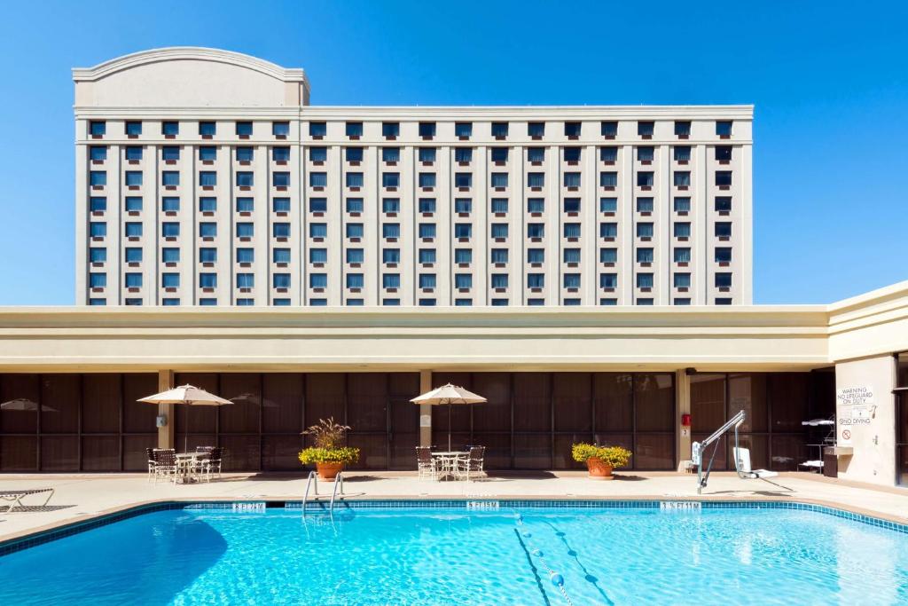 a hotel with a swimming pool in front of a building at Sonesta Atlanta Airport North in Atlanta