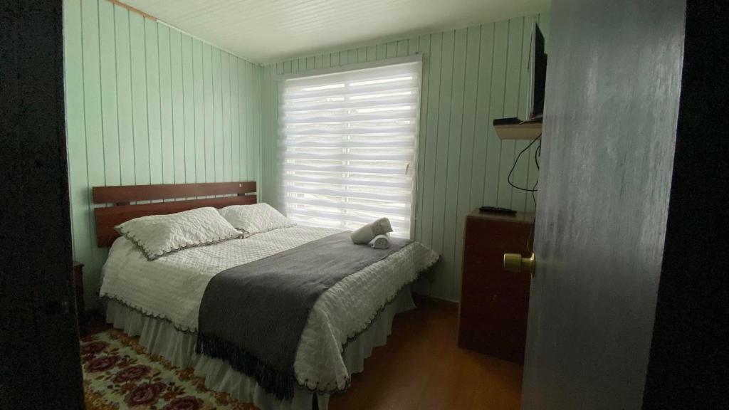 um quarto com uma cama com um urso de peluche em Hostería Ensenada em Puyuhuapi