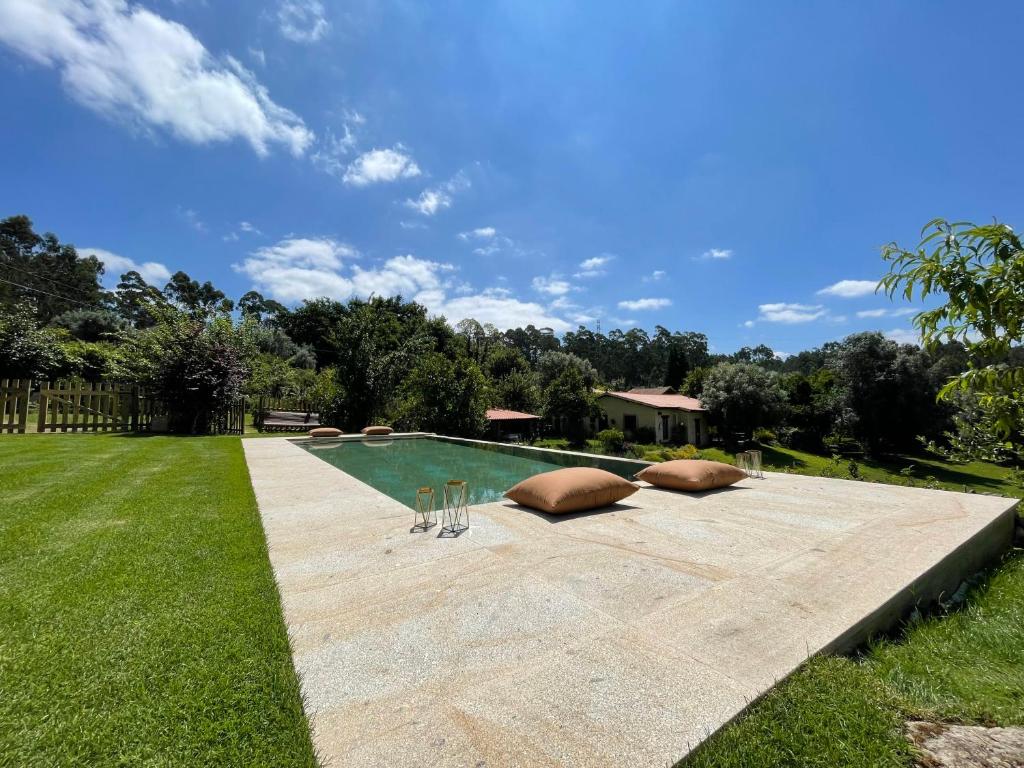 uma piscina com duas almofadas num quintal em Casa de Vilar de Rei, a tranquilidade do mundo rural em Ponte de Lima