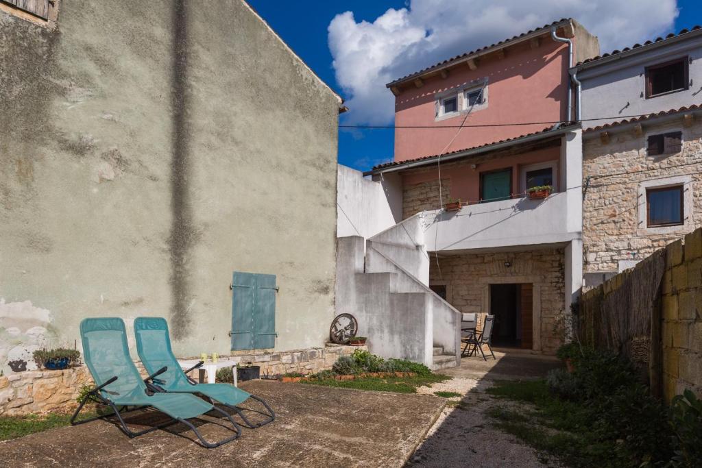 dos sillas azules sentadas fuera de un edificio en Holiday house with WiFi Rovinjsko Selo, Rovinj - 3431, en Rovinj