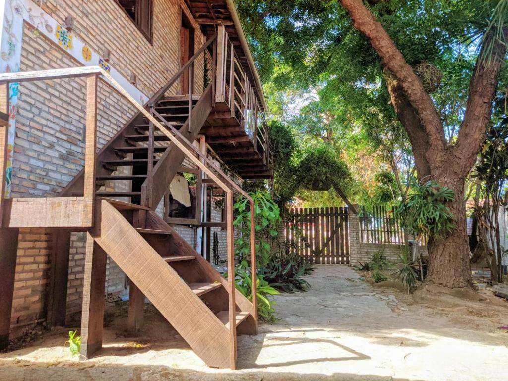 a wooden staircase next to a brick building with a tree at SAMO Hostel in Pipa