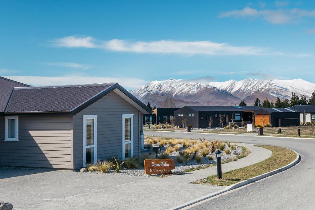 a building on the side of a road with mountains at Snowflake Tekapo in Lake Tekapo