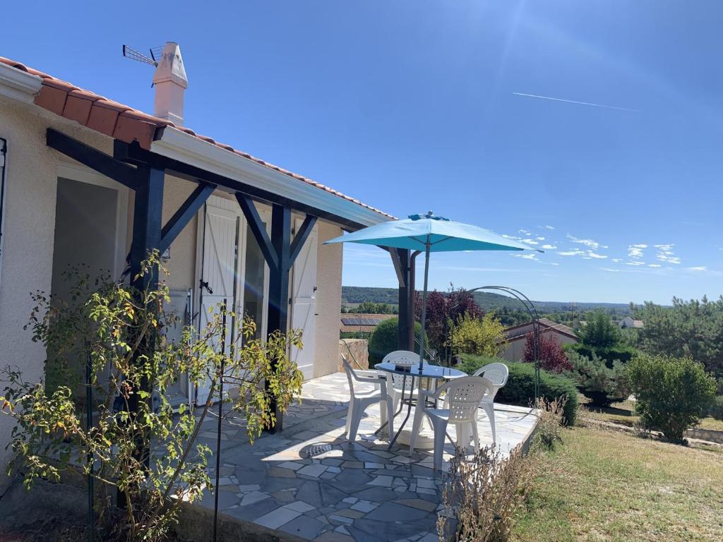 eine Terrasse mit einem Tisch und einem blauen Sonnenschirm in der Unterkunft Maison avec jardin près des Thermes, 2 chambres, équipements modernes, à La Roche-Posay - FR-1-541-33 in La Roche-Posay