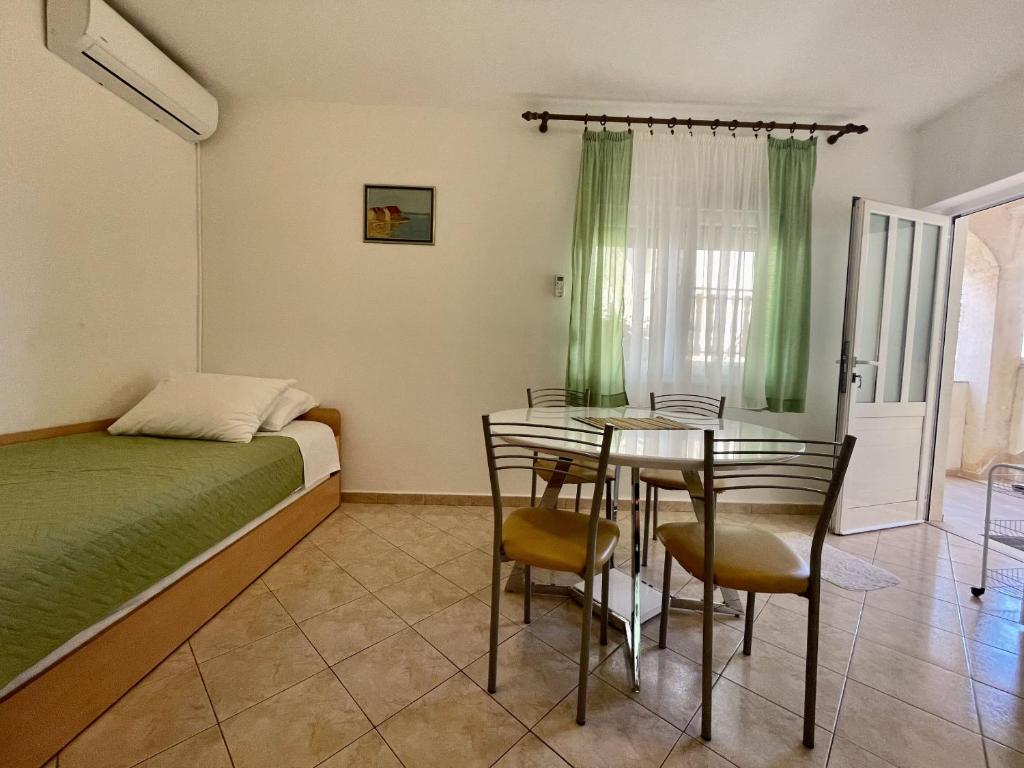 una camera da letto con un letto, un tavolo e delle sedie di Apartments Veli Rat a Veli Rat