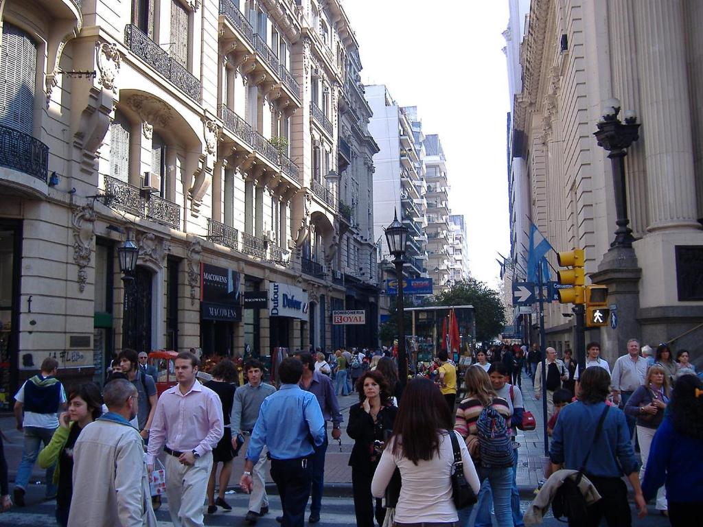 una multitud de personas caminando por una concurrida calle de la ciudad en Monoambiente con Patio Exelente ubicación en el Centro en Rosario