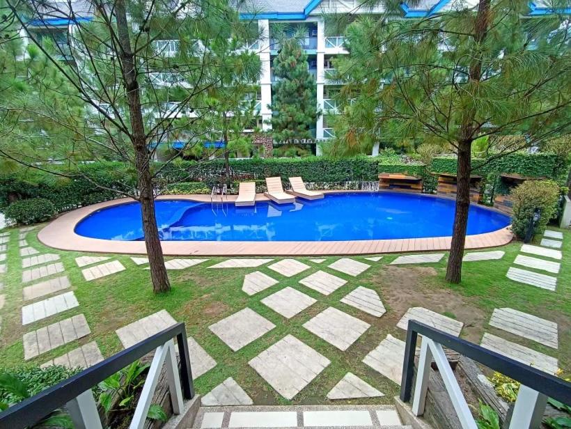 - une piscine dans une cour avec des chaises et des arbres dans l'établissement Love Marie, à Tagaytay