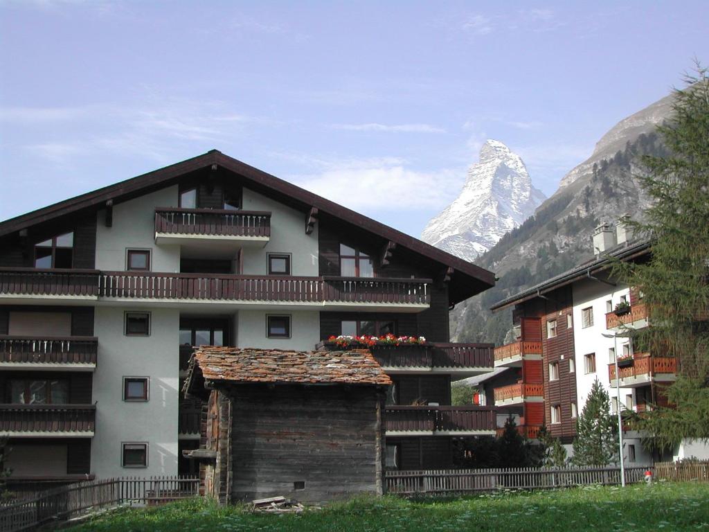 a apartment building with a mountain in the background at Haus Arbgrat in Zermatt