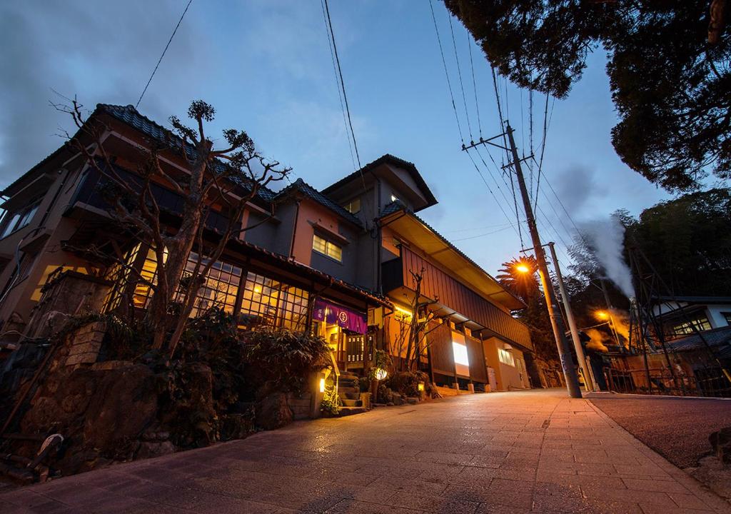 una calle vacía delante de un edificio por la noche en Ryokan Kiraku en Beppu