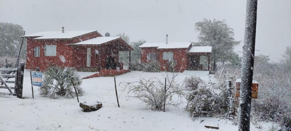 una casa cubierta de nieve delante en Ruka Inka en Villa Yacanto