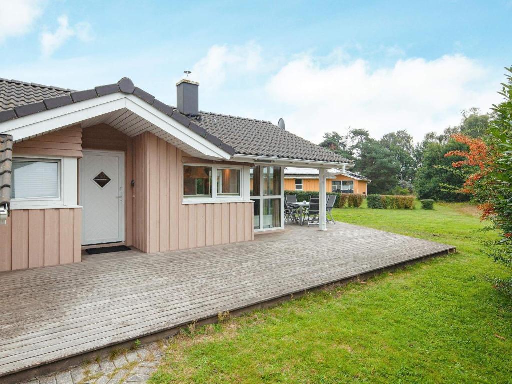 グレーミッツにあるThree-Bedroom Holiday home in Grömitz 5の庭に木製のデッキがある家