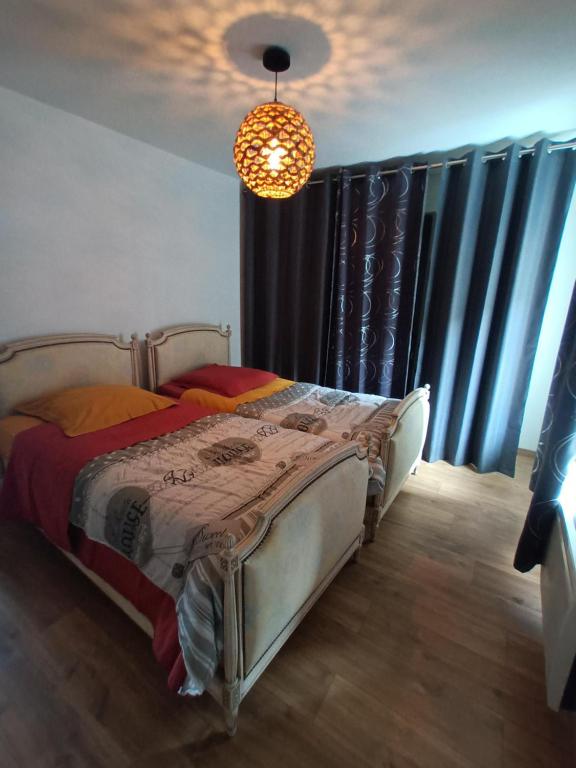 Schlafzimmer mit einem Bett mit Vorhängen und einem Kronleuchter in der Unterkunft Chemin du Grand Pré in Gripport