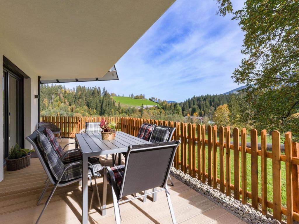 a patio with a table and chairs on a deck at Haus Hüttenberger in Going am Wilden Kaiser