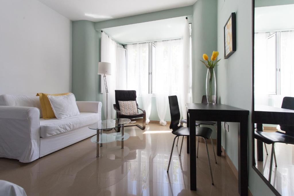 a living room with a white couch and a table at Apartamentos Edificio Constitución in Seville