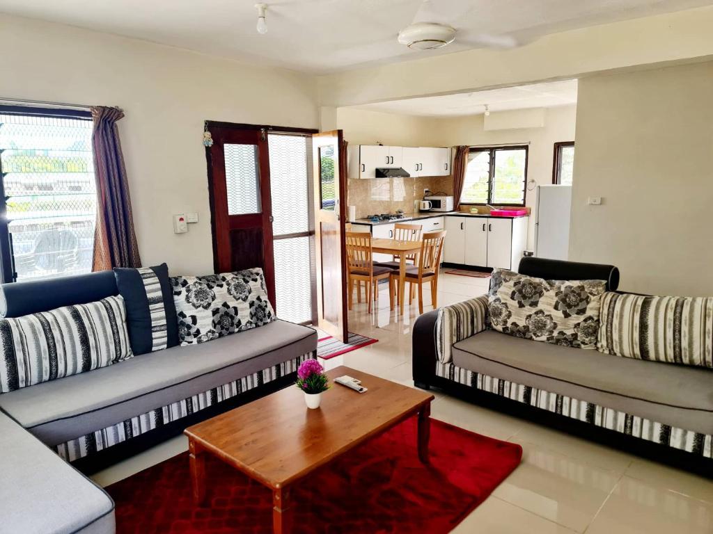 a living room with two couches and a coffee table at Masters 2 Bedroom Apartment Westfield in Nadi