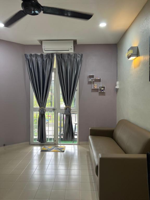 a living room with a couch and a large window at Batu Feringgi Homestay in Batu Ferringhi