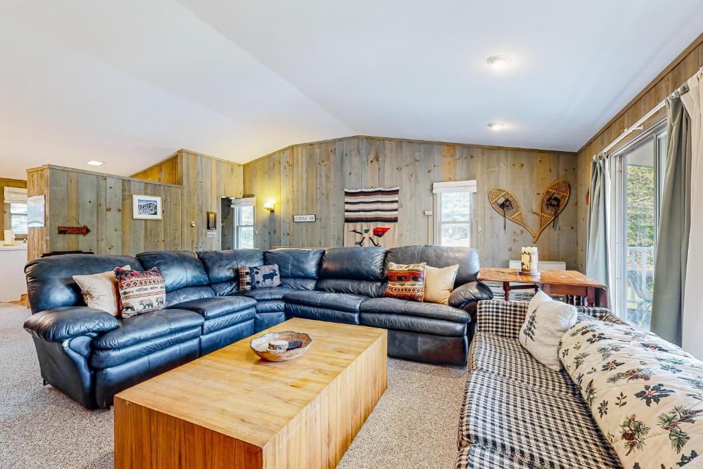 uma sala de estar com um sofá de couro e uma mesa em The Mountain House em Conway