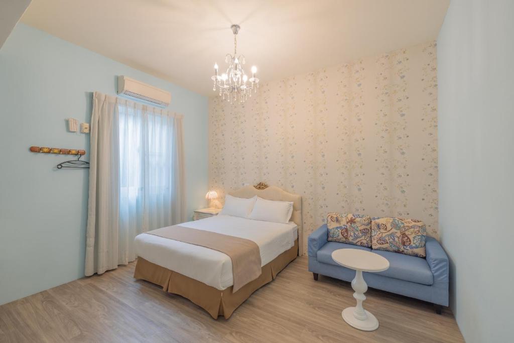 台東市的住宿－桔子圓包棟民宿 小團體包棟 tesla 充電，一间卧室配有一张床和一张蓝色椅子