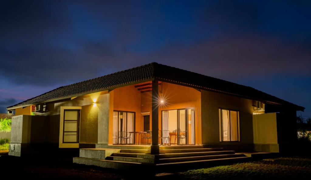 a small house with a porch at night at Touchwood Bliss Igatpuri in Nashik