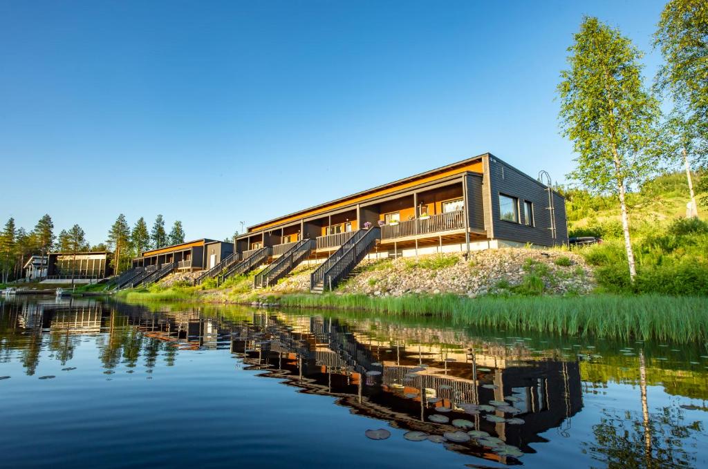 a house on a hill next to a body of water at Lake Residence Ukkohalla in Hyrynsalmi